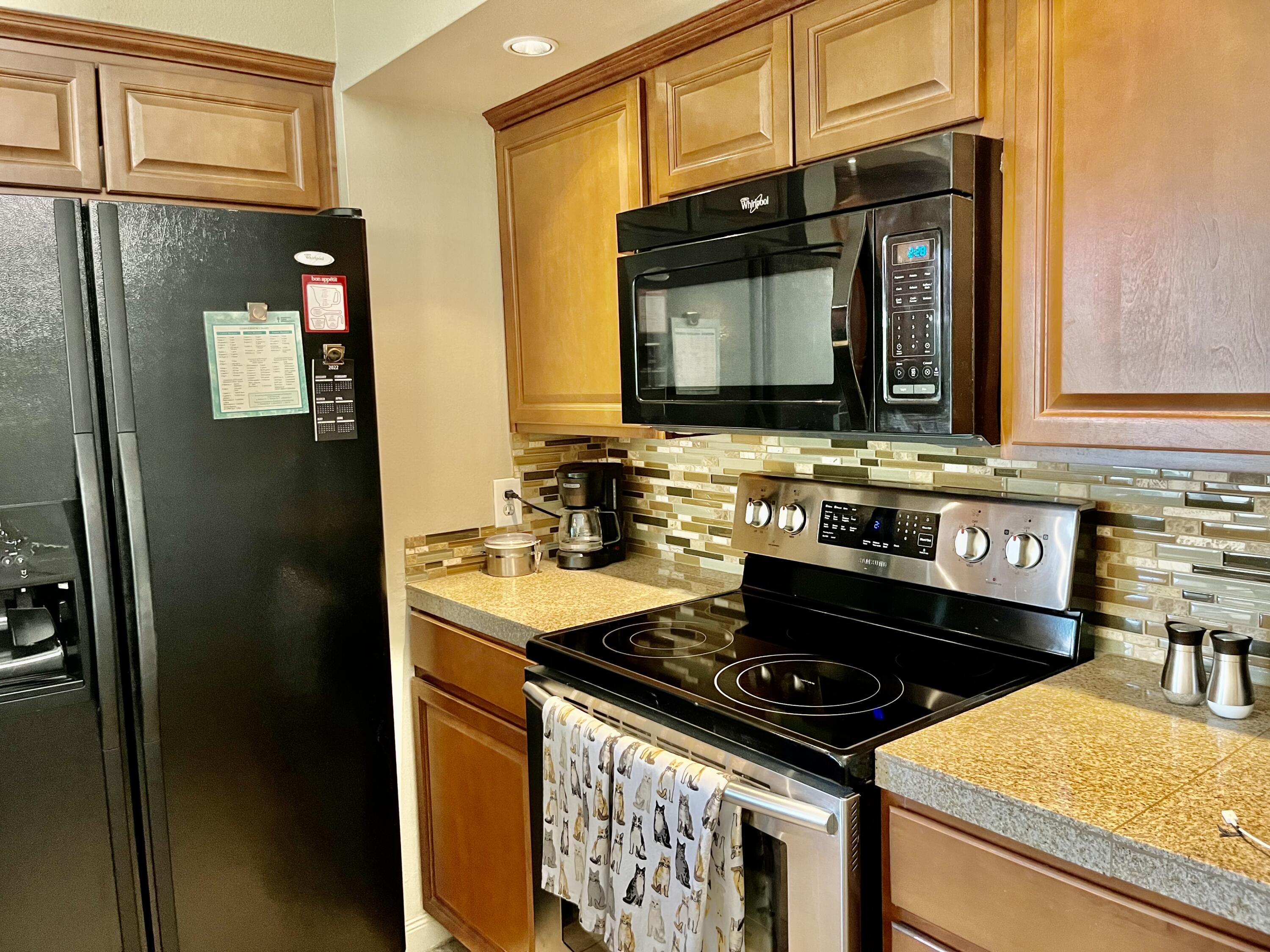127 South Racquet Club Drive Rancho Mirage, CA 92270 - Photo 9 of 25 a kitchen with stainless steel appliances granite countertop a stove and a microwave