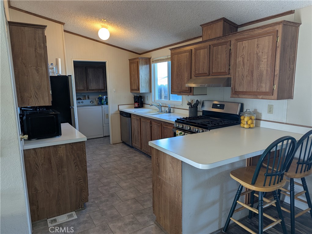 13182 Begonia Road Victorville, CA 92392 - Photo 2 of 17 a kitchen with a sink a stove a refrigerator a center island and a window