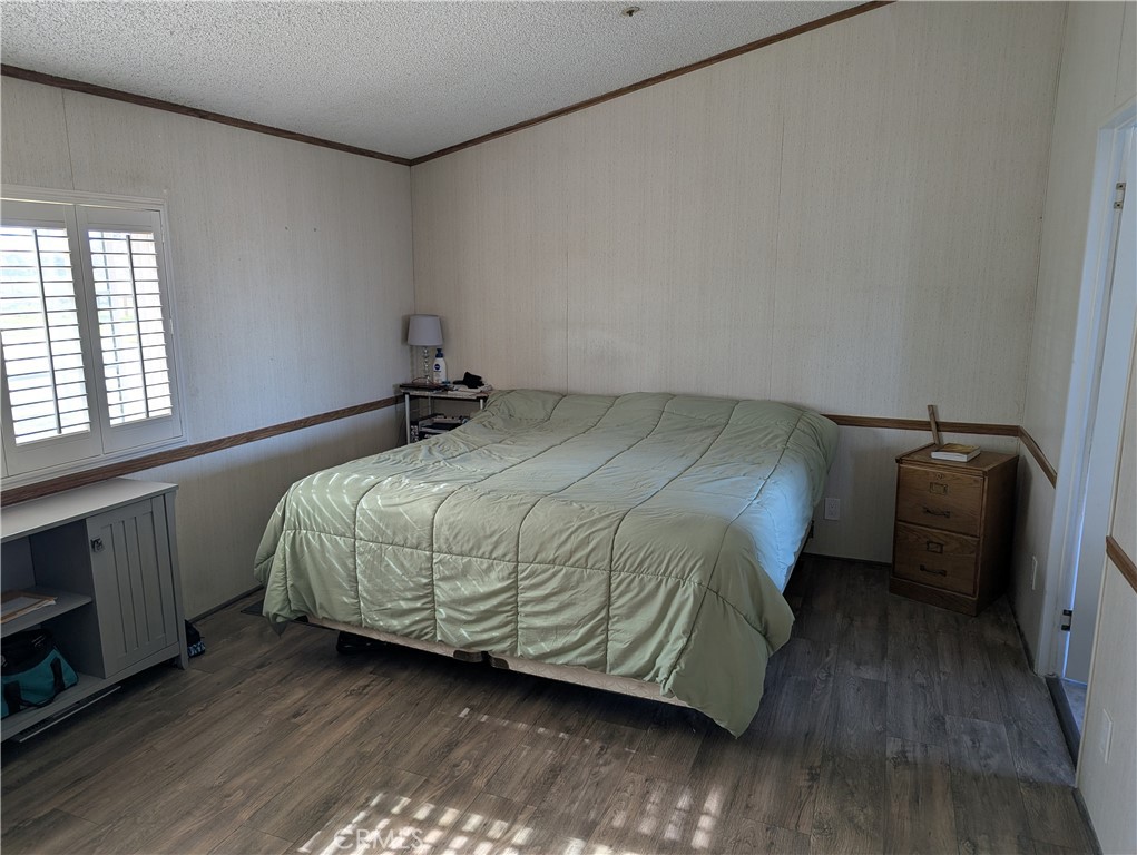 13182 Begonia Road Victorville, CA 92392 - Photo 7 of 17 a bedroom with a bed and wooden floor