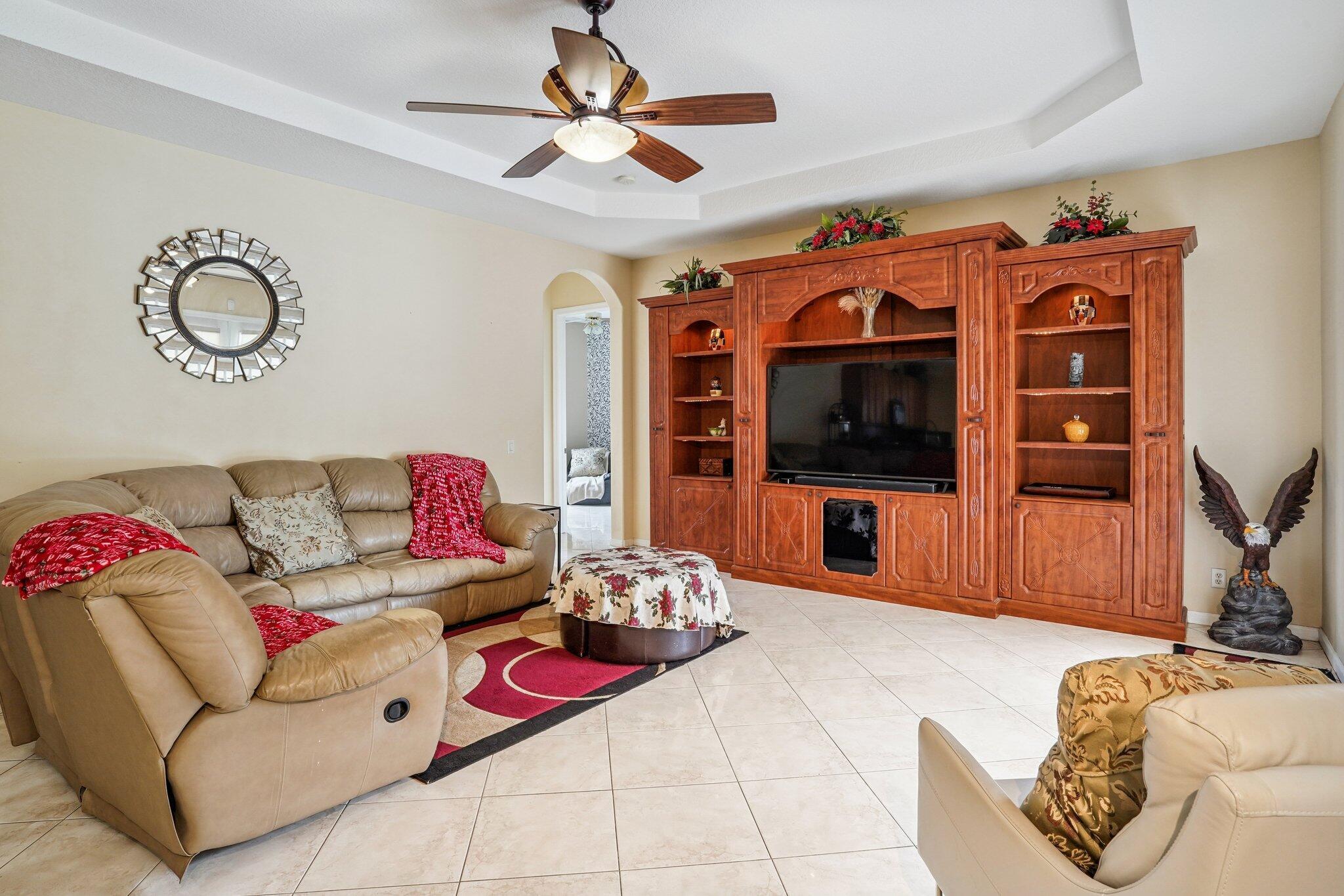 13554 86th Road North West Palm Beach, FL 33412 - Photo 28 of 58 a living room with furniture a flat screen tv and a chandelier