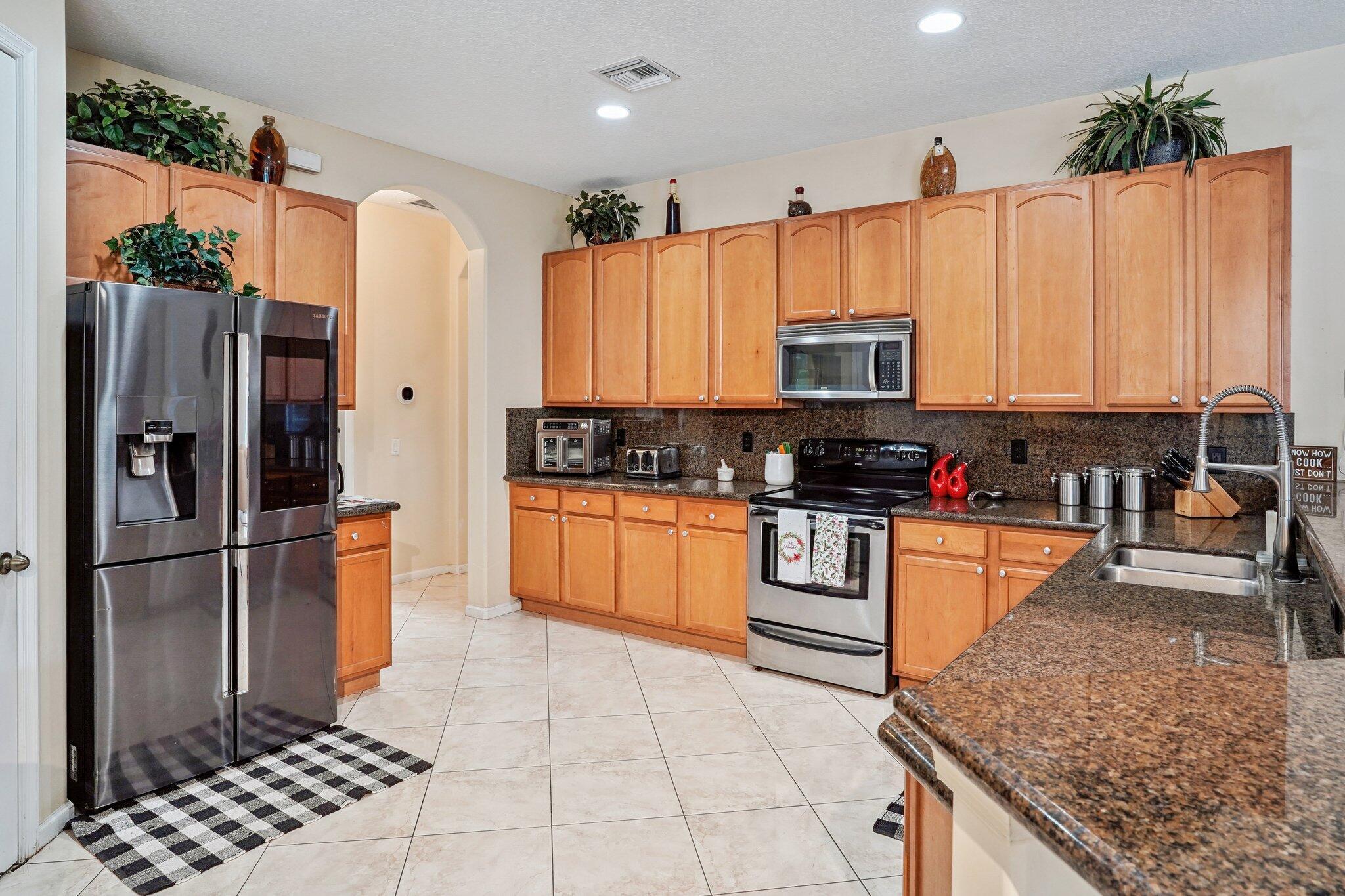 13554 86th Road North West Palm Beach, FL 33412 - Photo 31 of 58 a kitchen with stainless steel appliances granite countertop a refrigerator a stove and a sink