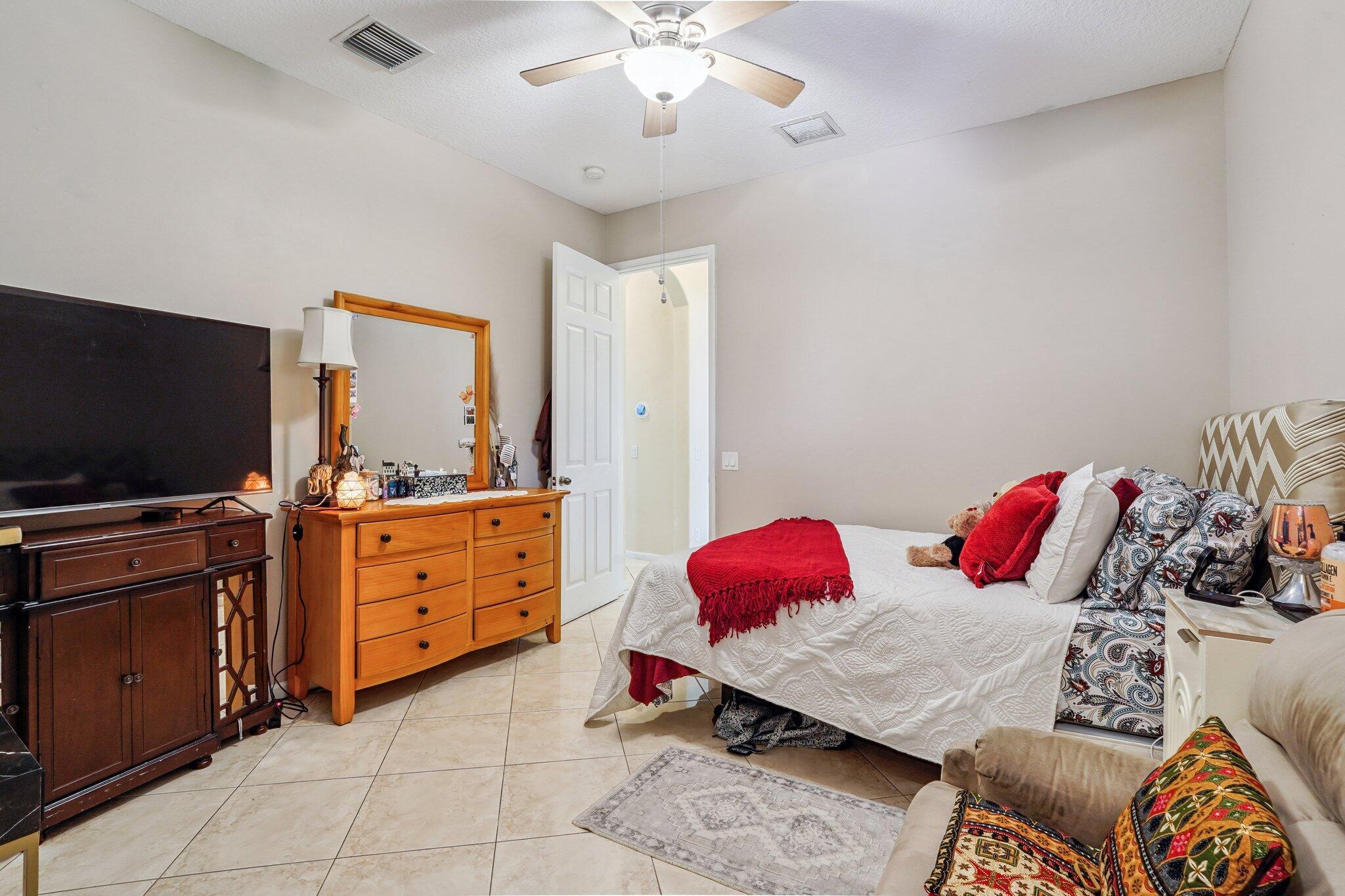 13554 86th Road North West Palm Beach, FL 33412 - Photo 46 of 58 a bedroom with a bed and flat screen tv
