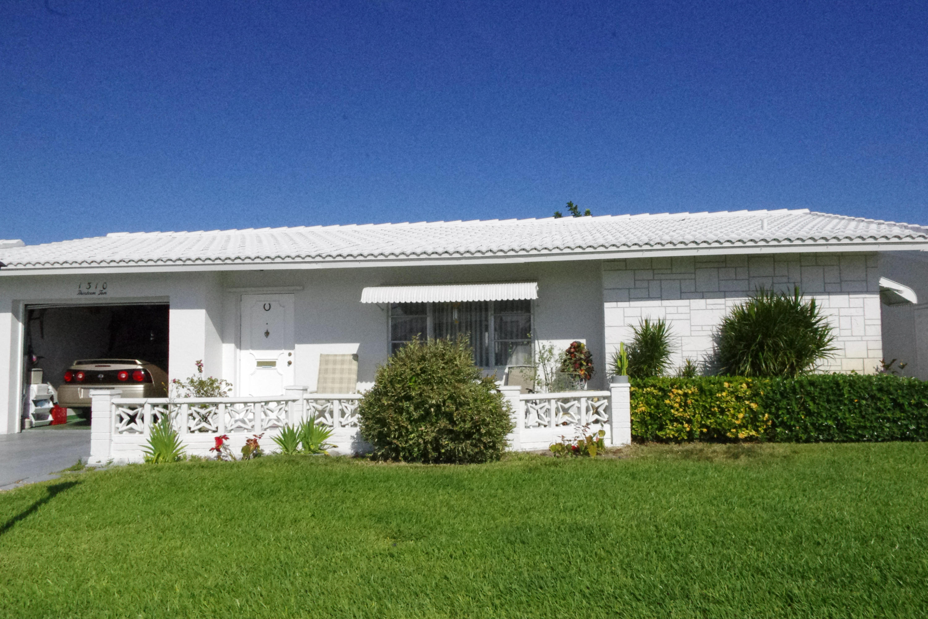 1310 Southwest 22nd Street Boynton Beach, FL 33426 - Photo 1 of 16 a front view of house with yard
