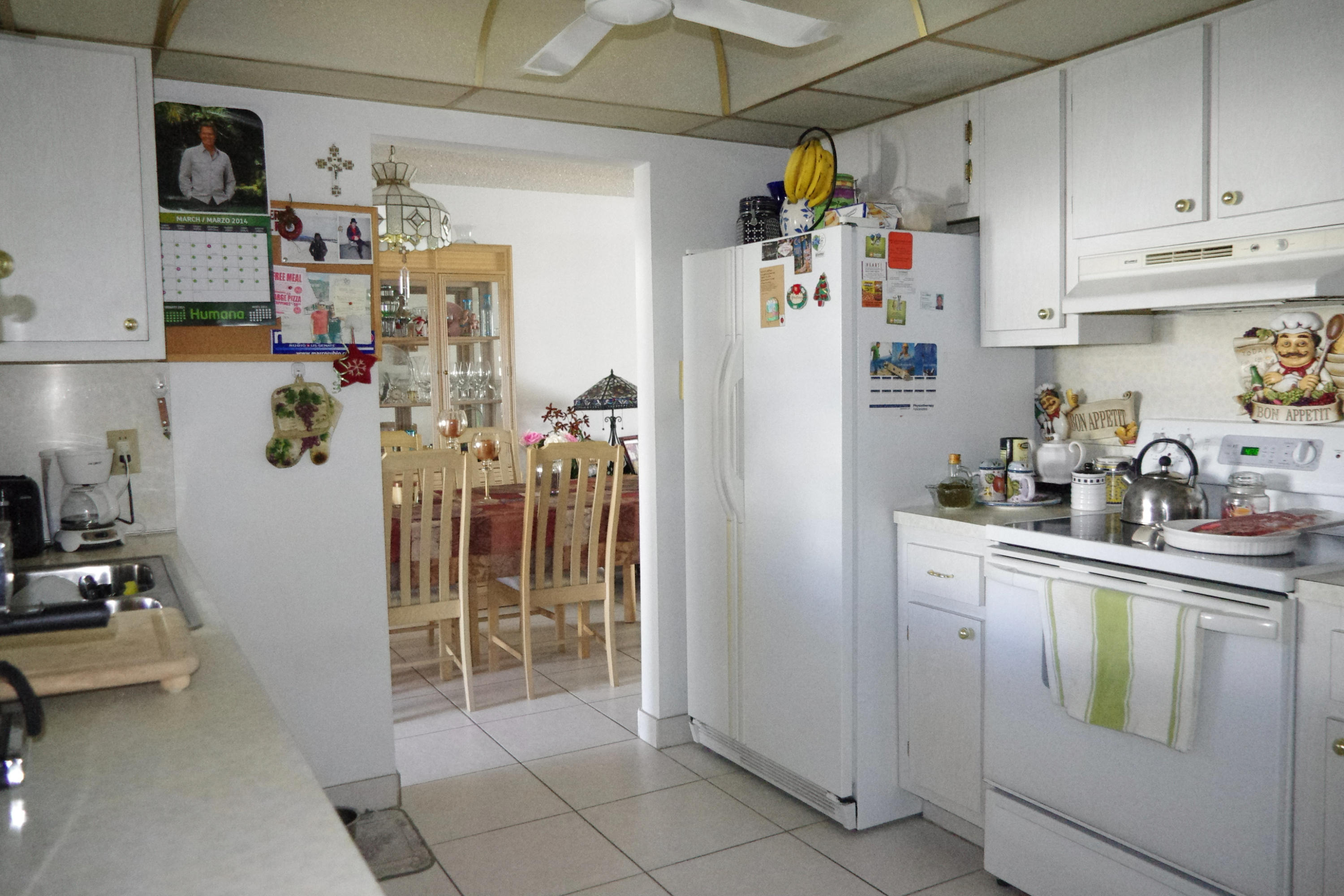1310 Southwest 22nd Street Boynton Beach, FL 33426 - Photo 13 of 16 a kitchen with refrigerator and cabinets