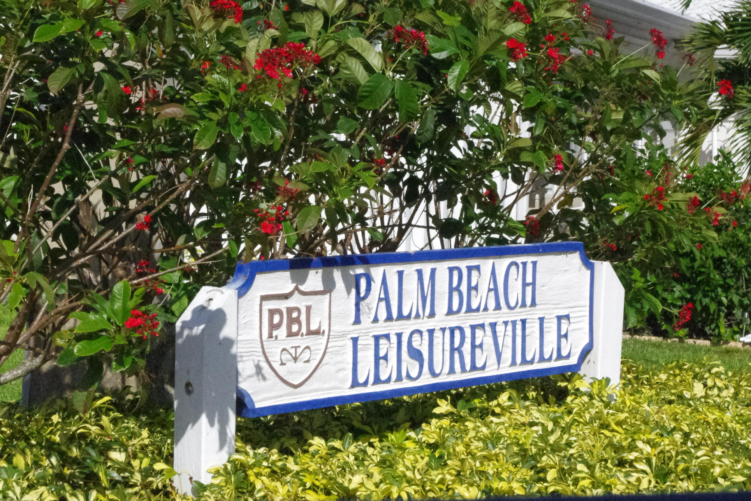 1310 Southwest 22nd Street Boynton Beach, FL 33426 - Photo 2 of 16 a view of a sign board with flower in a garden