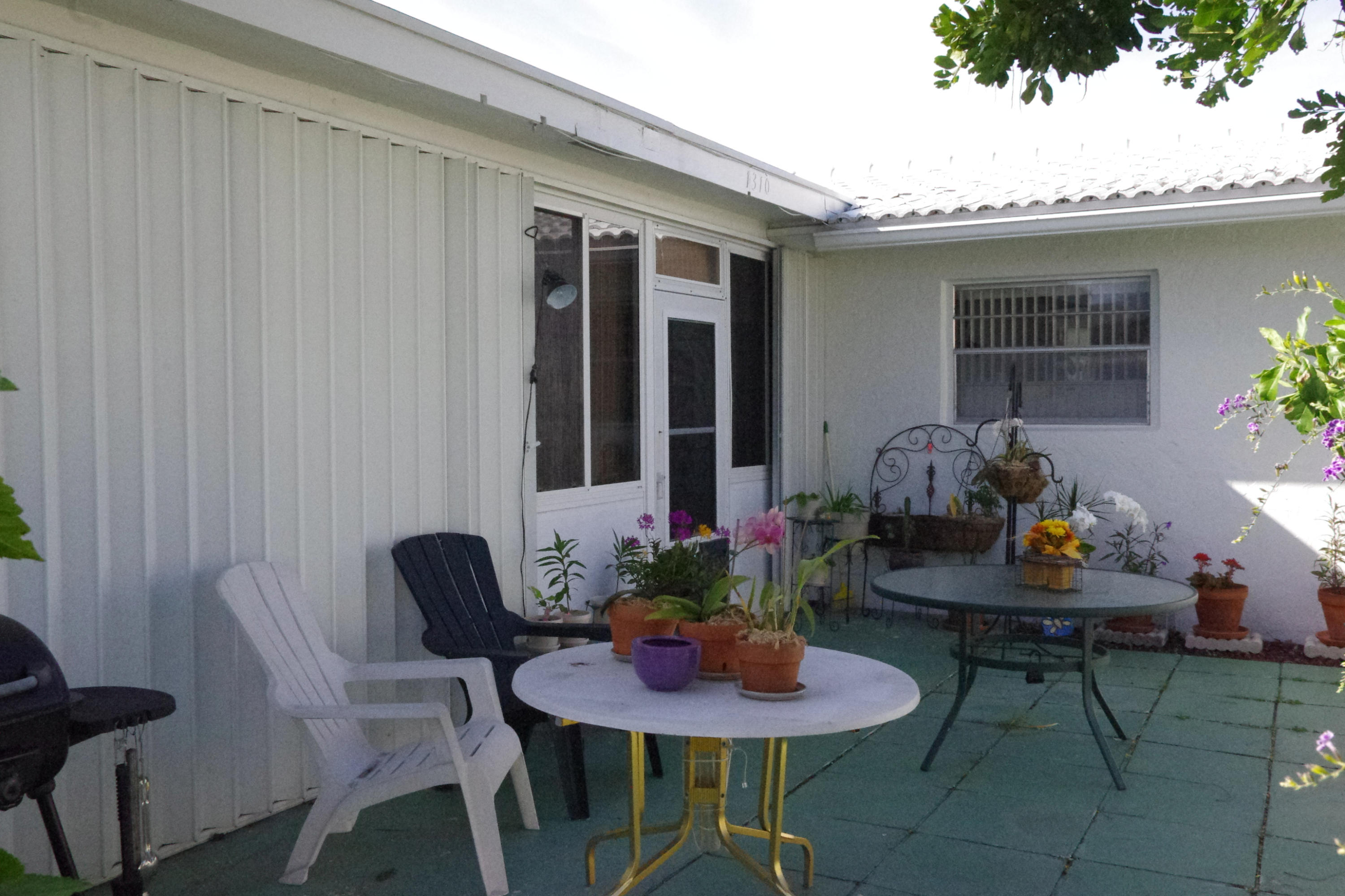 1310 Southwest 22nd Street Boynton Beach, FL 33426 - Photo 3 of 16 a outdoor dining space with furniture and a potted plant