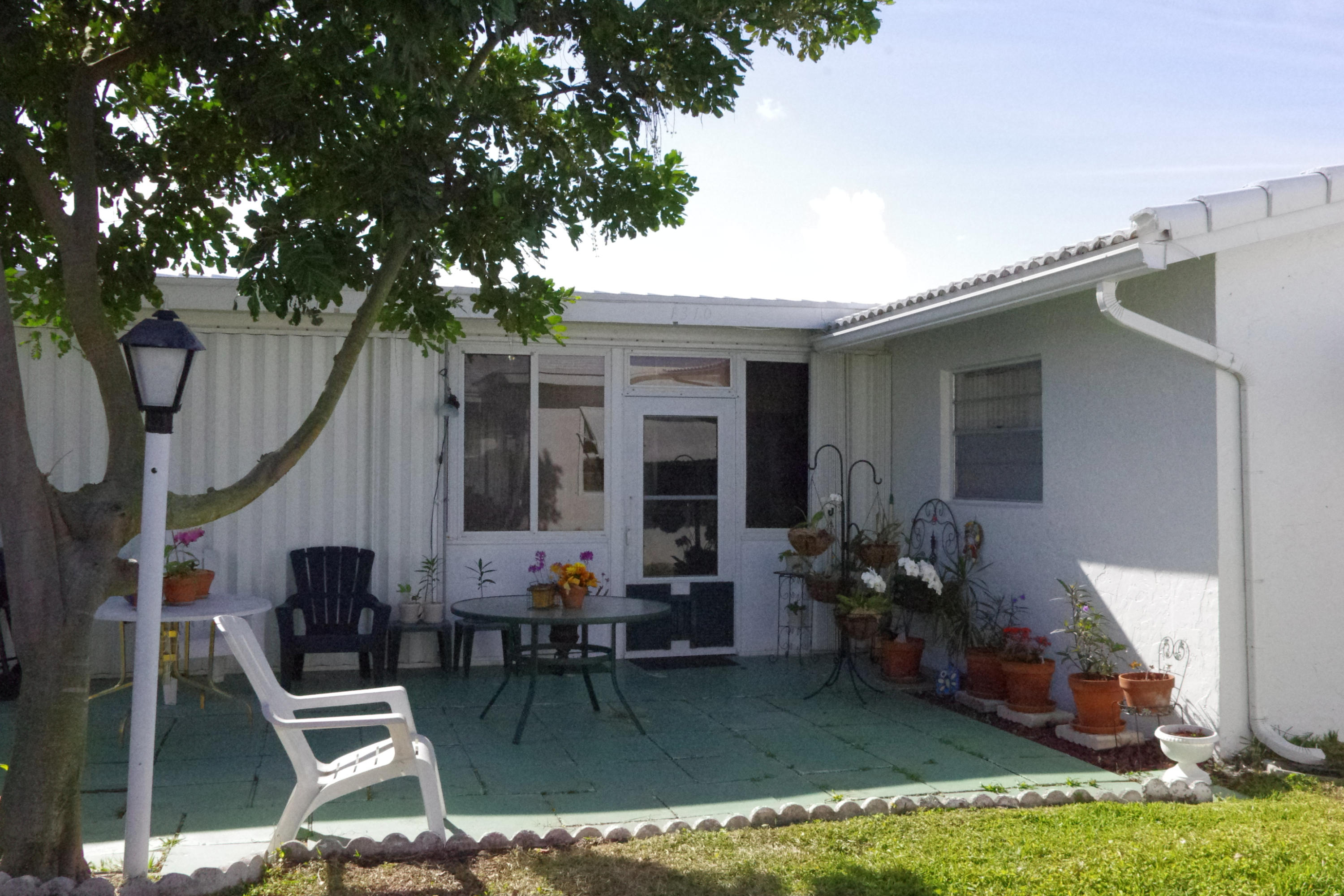 1310 Southwest 22nd Street Boynton Beach, FL 33426 - Photo 4 of 16 a patio with table and chairs