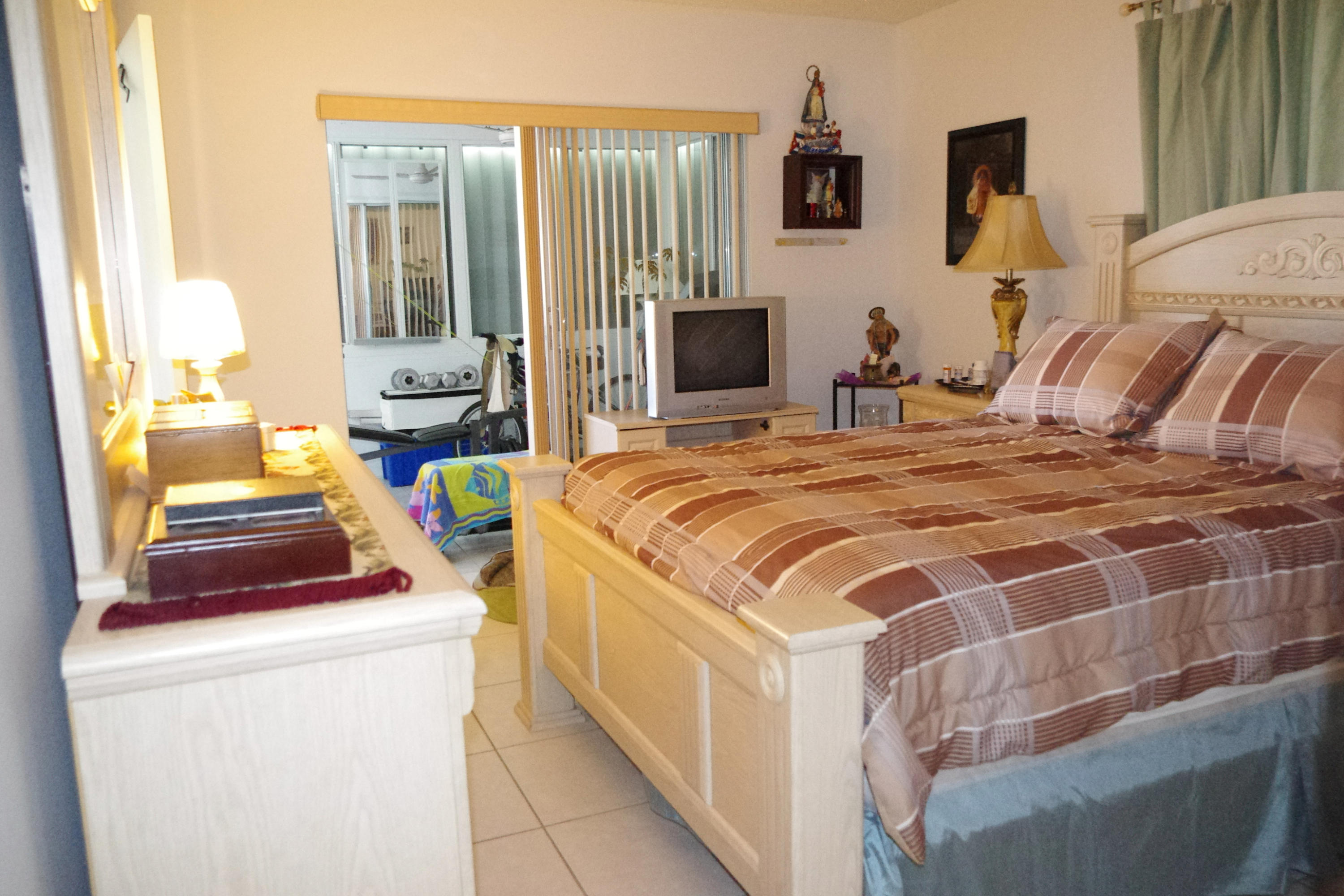 1310 Southwest 22nd Street Boynton Beach, FL 33426 - Photo 7 of 16 a bedroom with a bed and a tv
