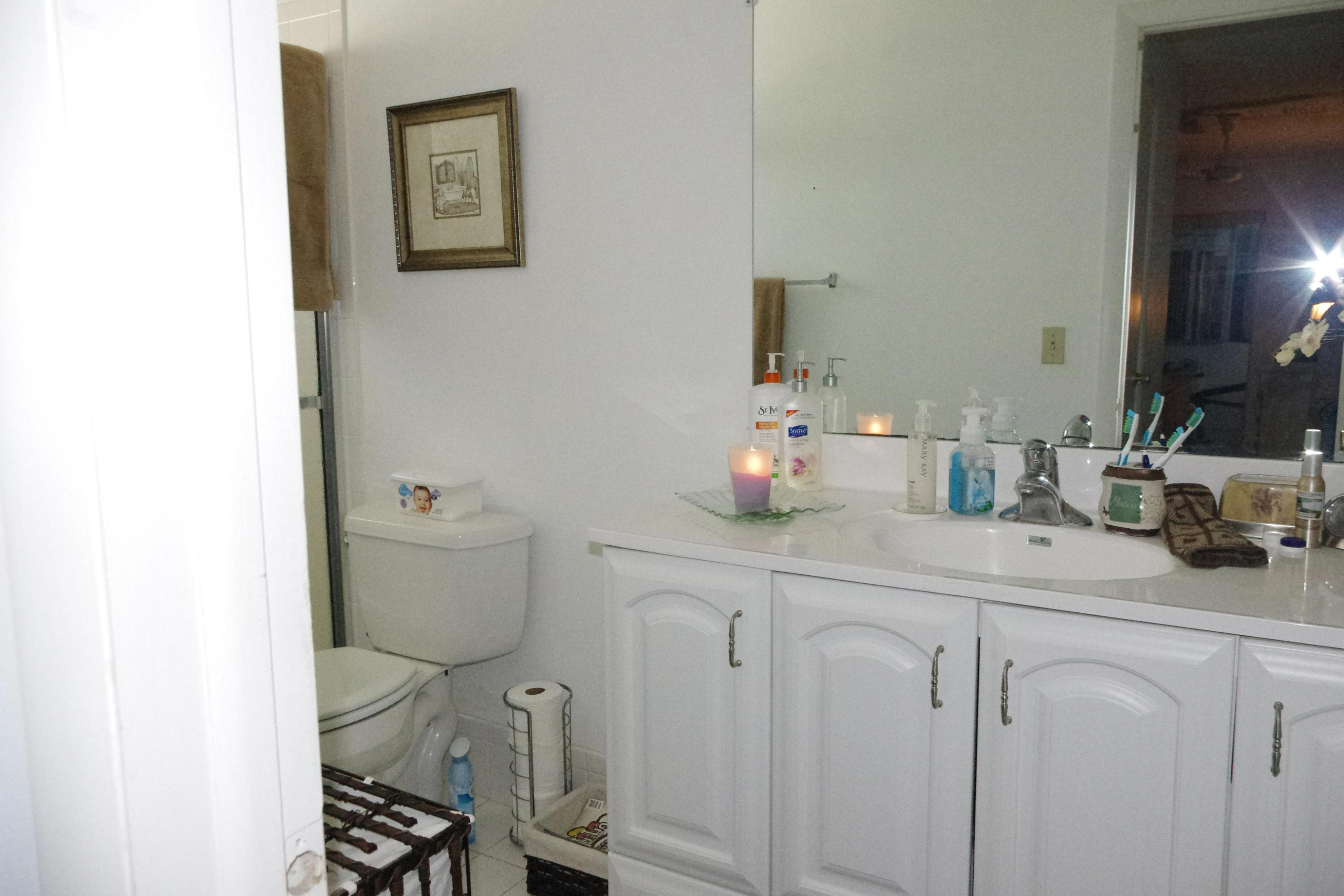 1310 Southwest 22nd Street Boynton Beach, FL 33426 - Photo 8 of 16 a bathroom with a sink a toilet and a mirror