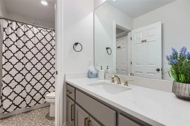 a bathroom with a sink a toilet and a mirror