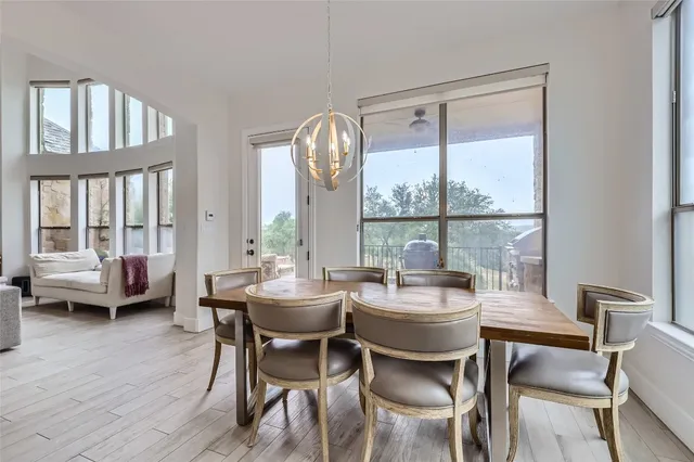 a dining room with furniture a chandelier and wooden floor