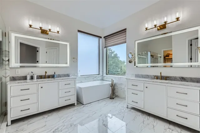 a bathroom with a granite countertop double vanity sink a mirror and a