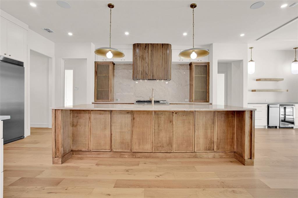 1839 Sentinel Way Tyler, TX 75703 - Photo 7 of 40 a large kitchen with stainless steel appliances kitchen island granite countertop a refrigerator a stove and a sink with wooden floor