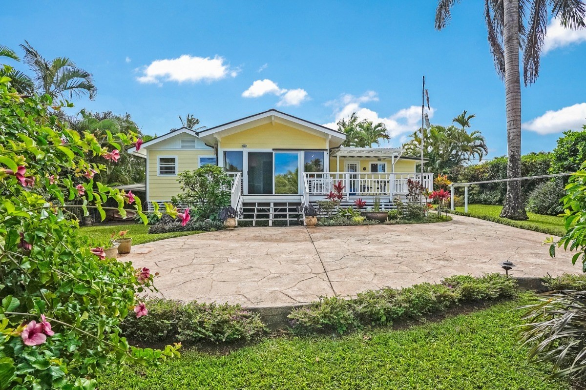 4378 Hookui Road Kilauea, HI 96754 - Photo 17 of 29 a front view of a house with a yard and potted plants