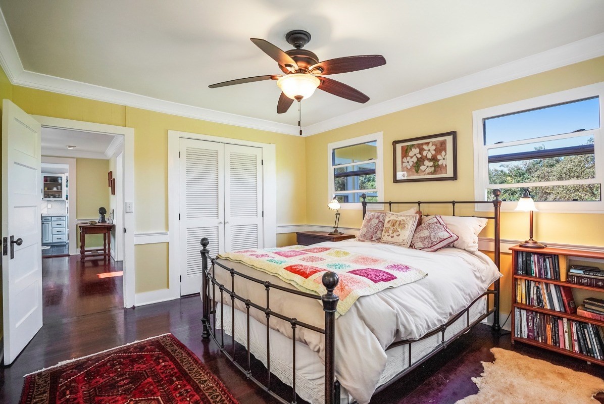 4378 Hookui Road Kilauea, HI 96754 - Photo 9 of 29 a bedroom with a bed and wooden floor
