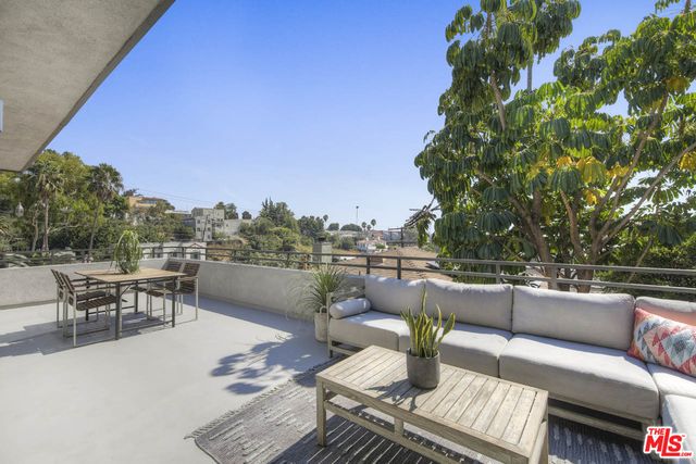 a roof deck with couches and potted plants