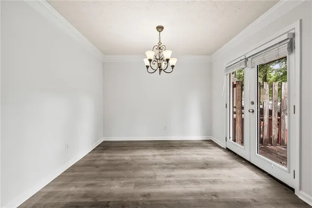 a view of a hallway with wooden floor and a chandelier