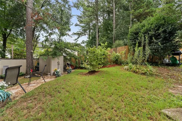 a view of a backyard with table and chairs and a large tree