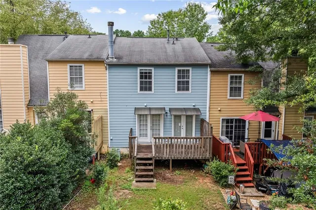 a view of a house with a yard and potted plants