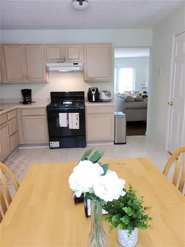 a kitchen with a stove a sink and a white cabinets