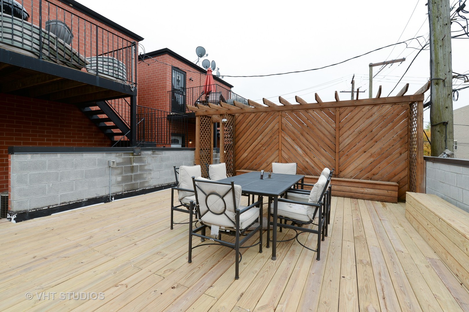 514 South Denvir Avenue, Unit 2 Chicago, IL 60612 - Photo 13 of 13 a view of a roof deck with table and chairs with wooden floor and fence