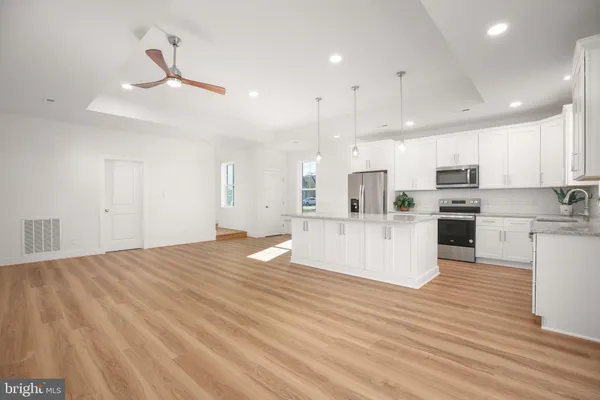 a kitchen with stainless steel appliances granite countertop a sink stove microwave and refrigerator