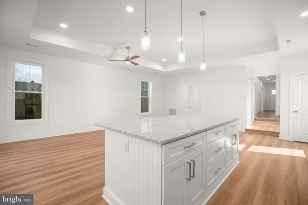 a large kitchen with white cabinets a sink a window and stainless steel appliances