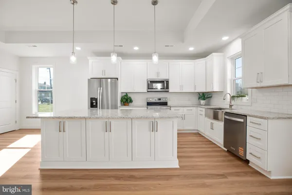 a view of kitchen with cabinets appliances and wooden floor