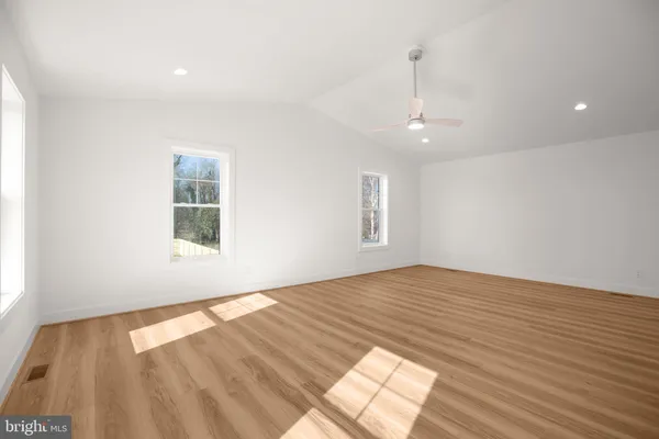 a view of an empty room with wooden floor
