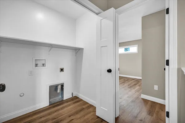 a view of a hallway with wooden floor and closet