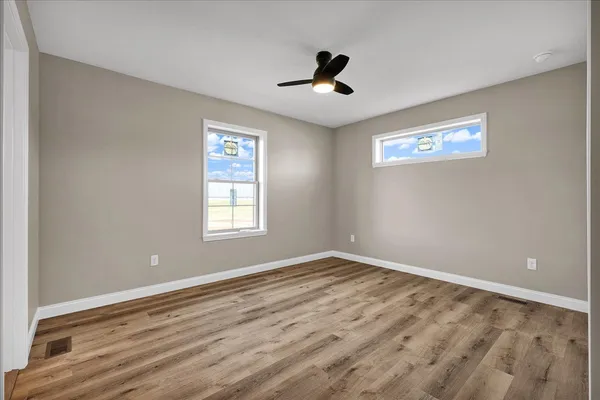 a view of empty room with wooden floor
