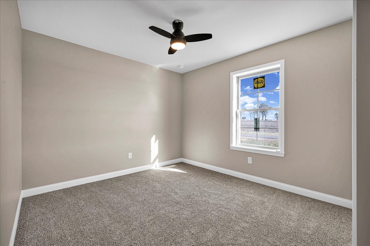 180 South Oak Street El Paso, IL 61738 - Photo 21 of 32 an empty room with ceiling fan and windows
