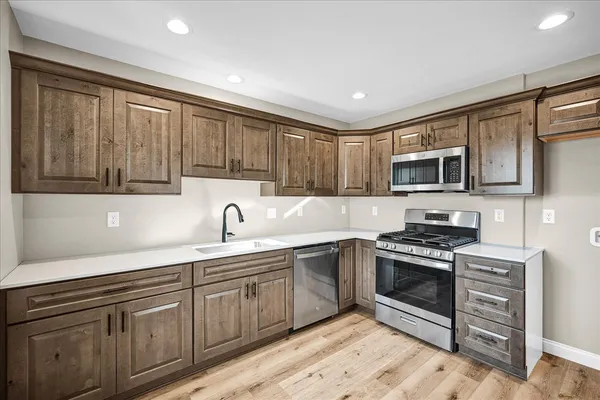 a kitchen with stainless steel appliances granite countertop a sink stove and microwave