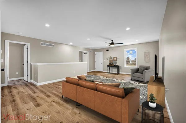 a living room with furniture and a dining table with wooden floor