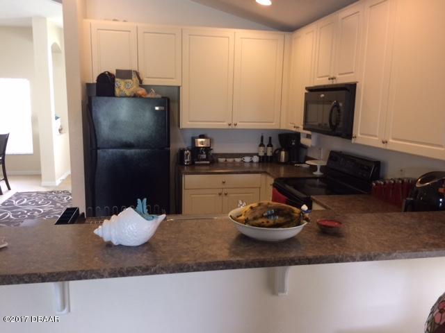 812 Star Reef Lane Edgewater, FL 32132 - Photo 4 of 17 a kitchen with a refrigerator and a stove
