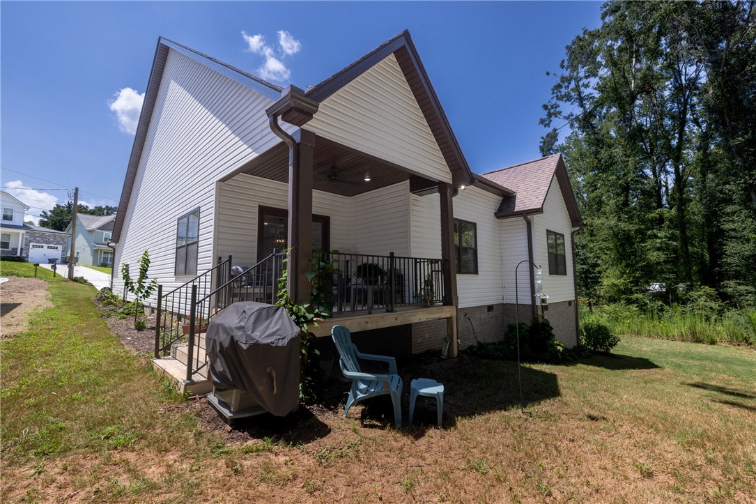 322 Thompson Street Pendleton, SC 29670 - Photo 31 of 38 A covered back porch overlooks the grassy yard bordered by mature trees.