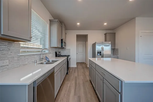 a kitchen with kitchen island a sink stove and refrigerator