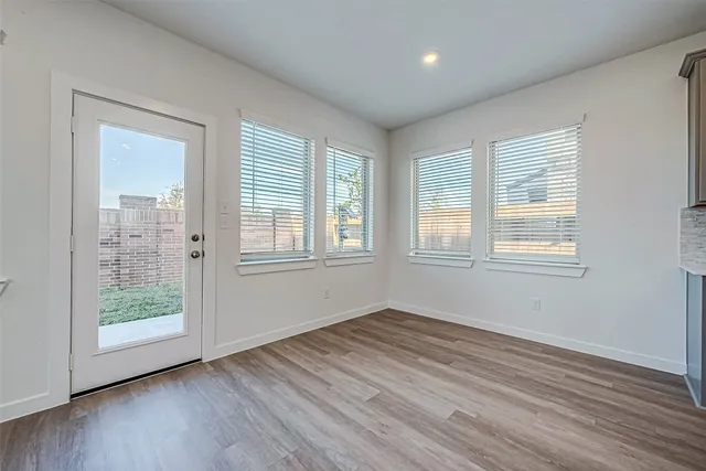 a large kitchen with kitchen island a sink wooden floor and stainless steel appliances