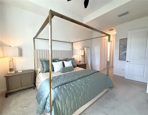 a bedroom with a bed and a lamp next to a window