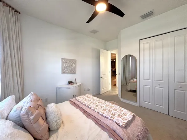 a bedroom with a large bed and a chandelier