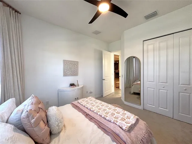 a bedroom with a large bed and a chandelier
