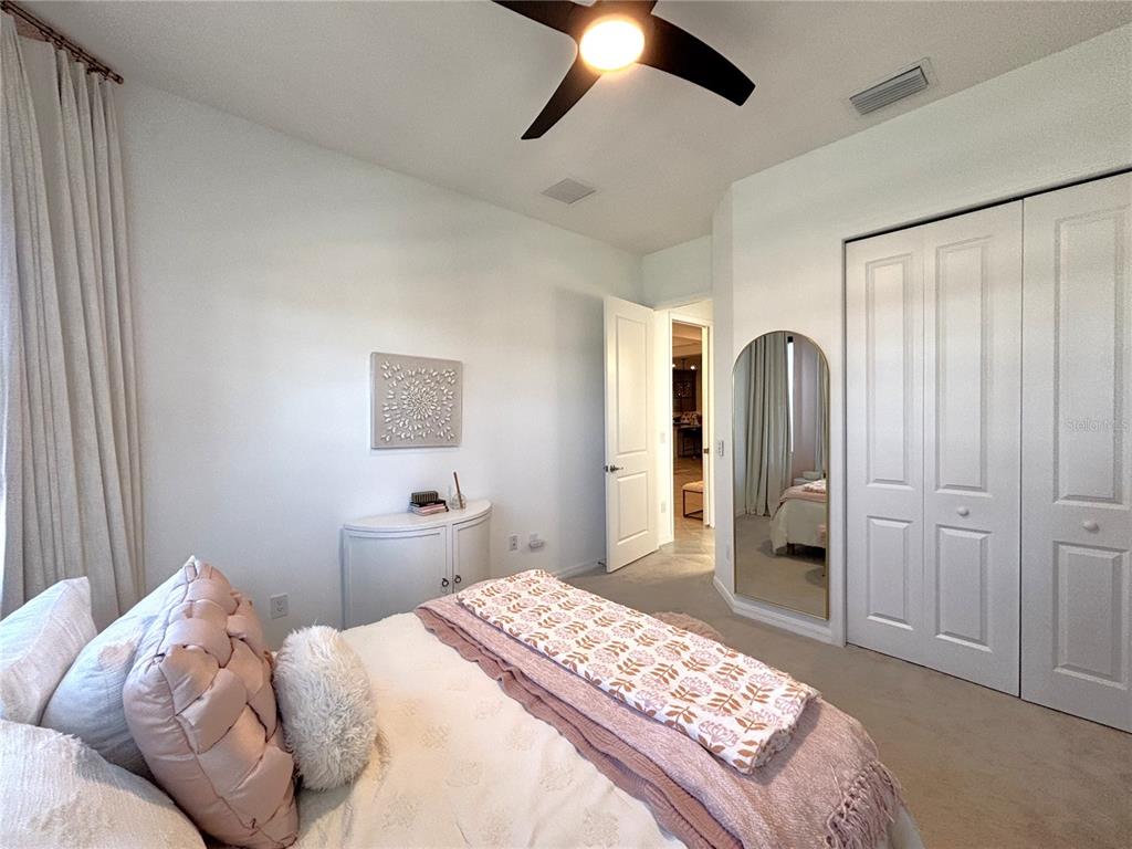 17510 Jadestone Court Venice, FL 34293 - Photo 17 of 46 a bedroom with a large bed and a chandelier