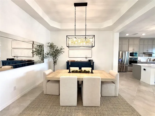 a room with stainless steel appliances kitchen island granite countertop a sink a stove and a refrigerator