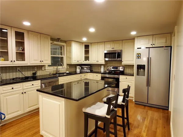 a kitchen with kitchen island a refrigerator stove and microwave