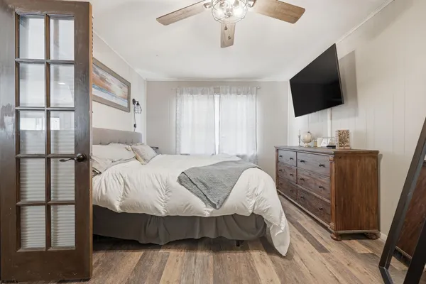a bedroom with a bed tv and a window