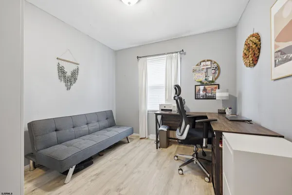 a work room with furniture a rug and a window