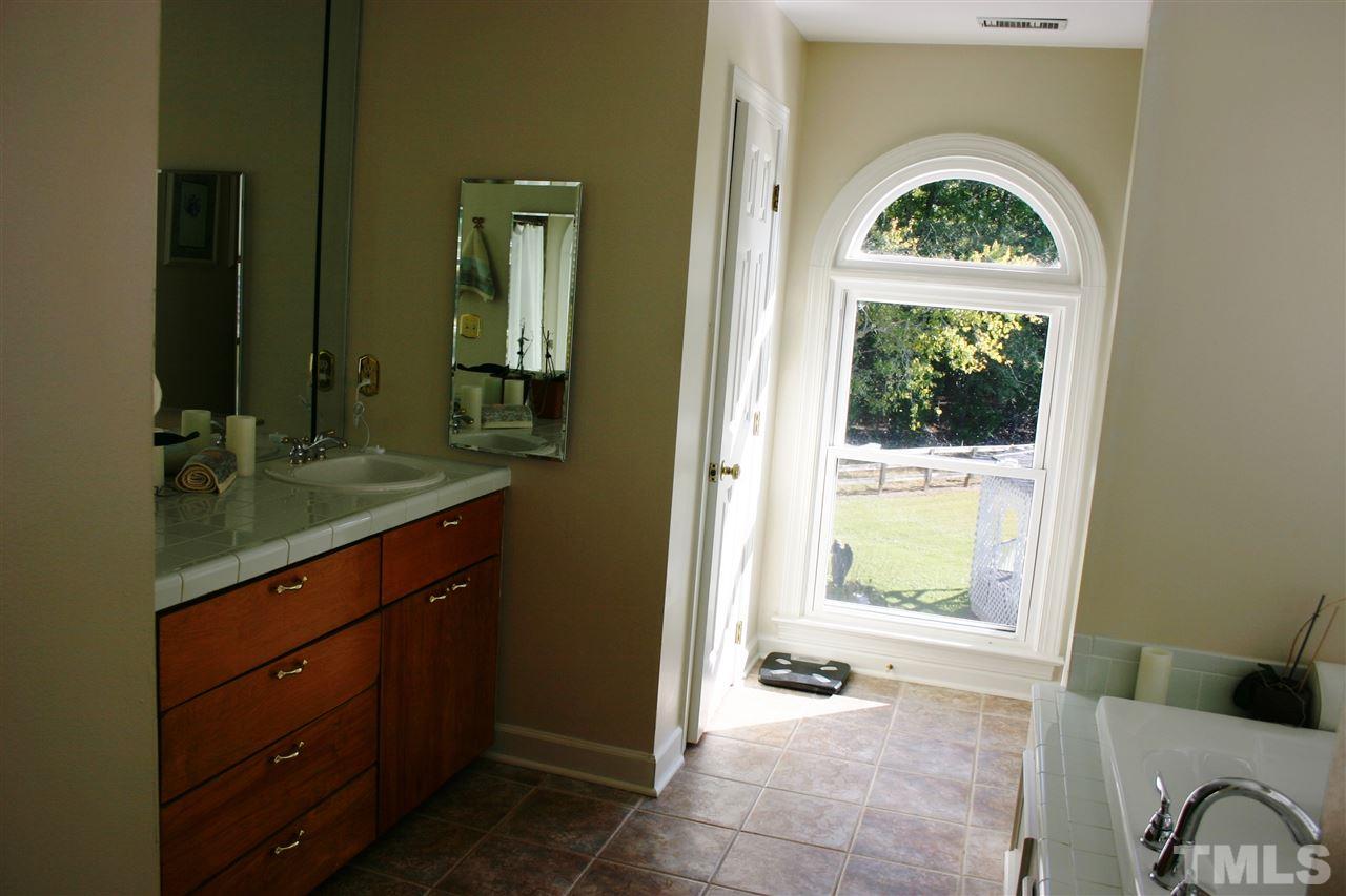 307 Bacon Road Rougemont, NC 27572 - Photo 16 of 25 a bathroom with a granite countertop sink a mirror and a window
