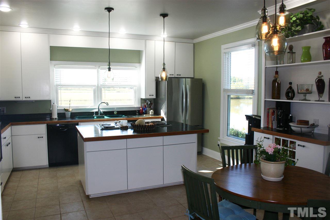 307 Bacon Road Rougemont, NC 27572 - Photo 8 of 25 a kitchen with stainless steel appliances granite countertop a sink dishwasher a refrigerator a stove and a dining table with wooden cabinet
