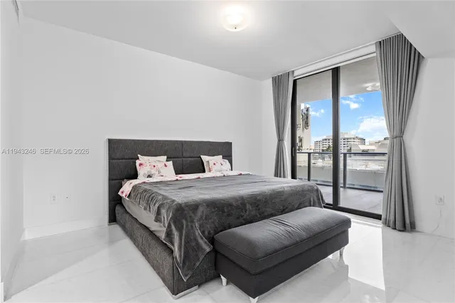 a bedroom with a bed couch and a large window