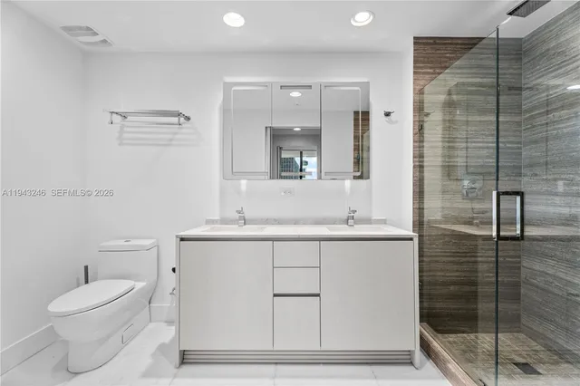 a bathroom with a sink a toilet and shower